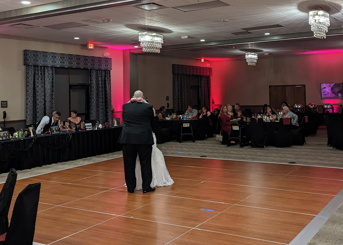 A couple's first dance with red uplighting in the room